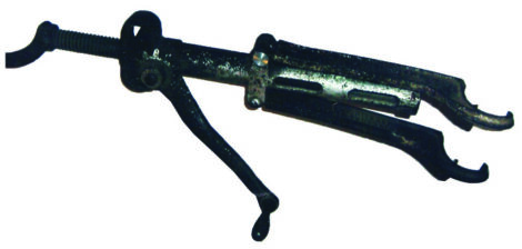 old metal tool with a crank on one end and a hooked opening on the…